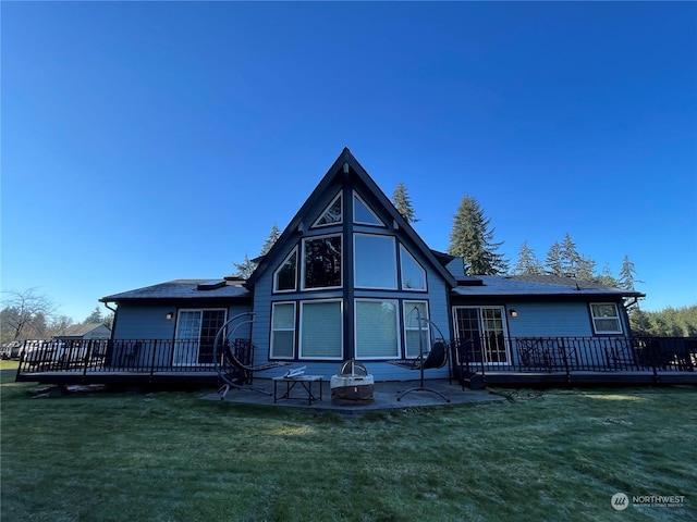 back of house with a fire pit, a lawn, a patio, and a deck