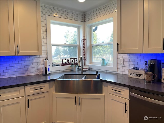 kitchen with tasteful backsplash, sink, stainless steel dishwasher, and white cabinets