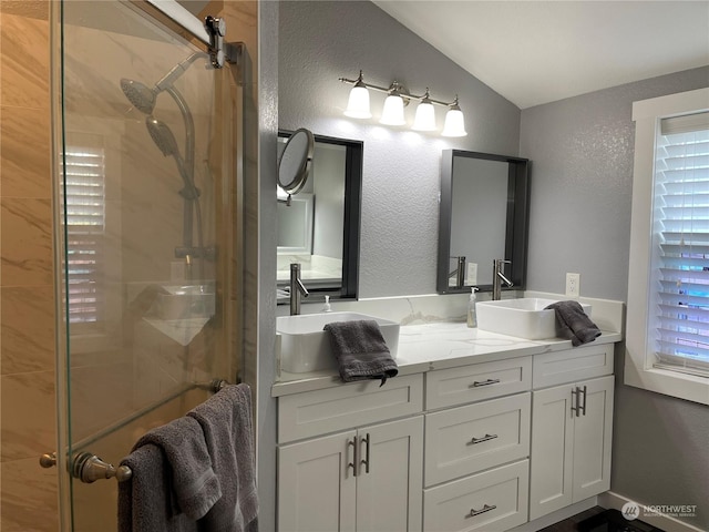 bathroom with vaulted ceiling, an enclosed shower, and vanity