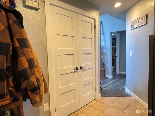 hall with light tile patterned floors