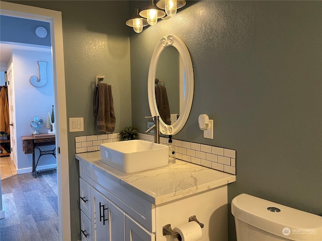 bathroom with wood-type flooring, vanity, and toilet