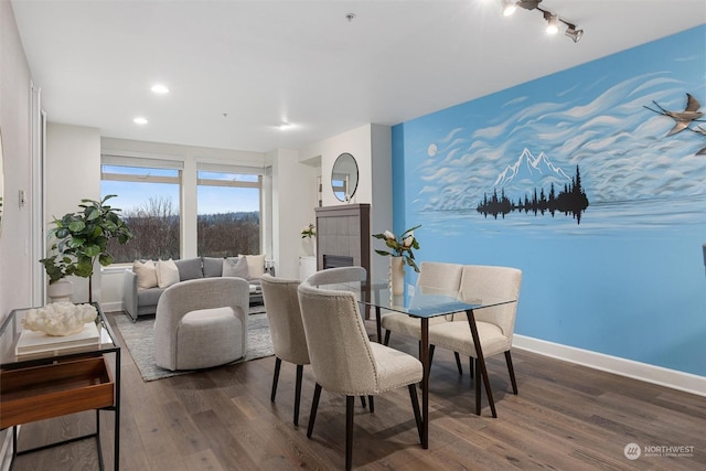 dining room featuring dark wood-type flooring and a tile fireplace