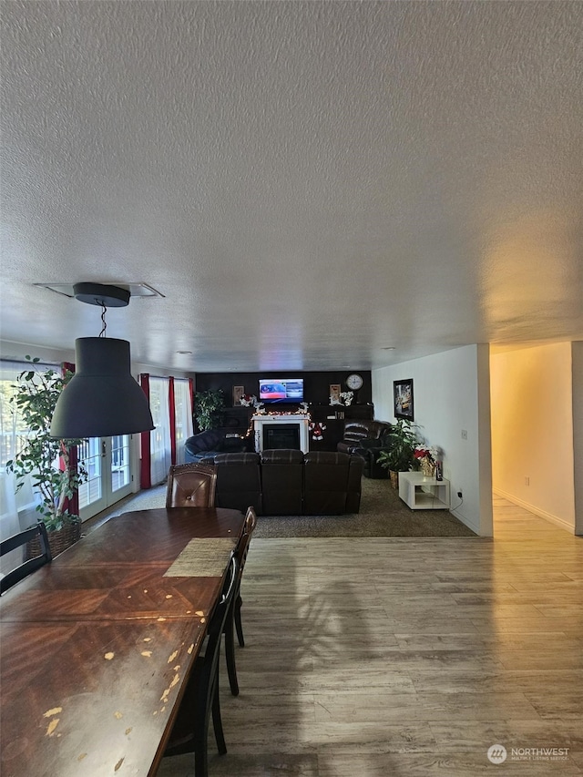 dining area featuring wood-type flooring and a textured ceiling