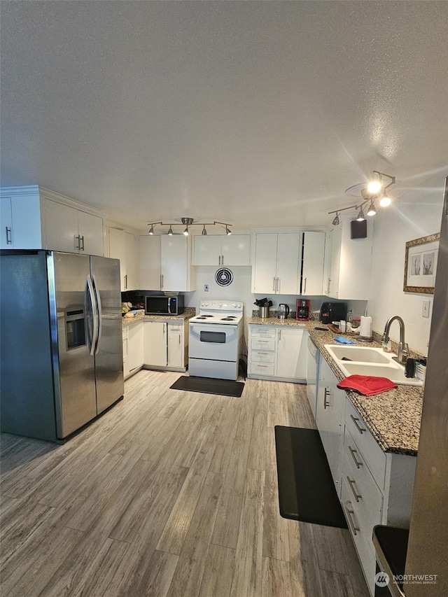 kitchen with sink, a textured ceiling, light hardwood / wood-style flooring, appliances with stainless steel finishes, and white cabinets