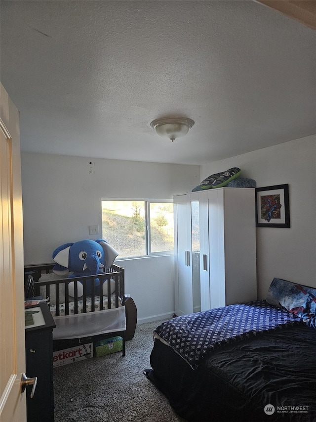 bedroom with carpet floors and a textured ceiling