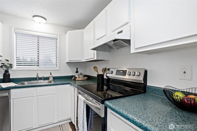 kitchen featuring dark countertops, appliances with stainless steel finishes, white cabinetry, a sink, and under cabinet range hood