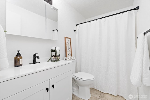 full bath featuring toilet, vanity, visible vents, and tile patterned floors