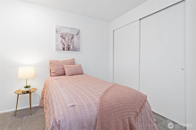 carpeted bedroom with baseboards and a closet