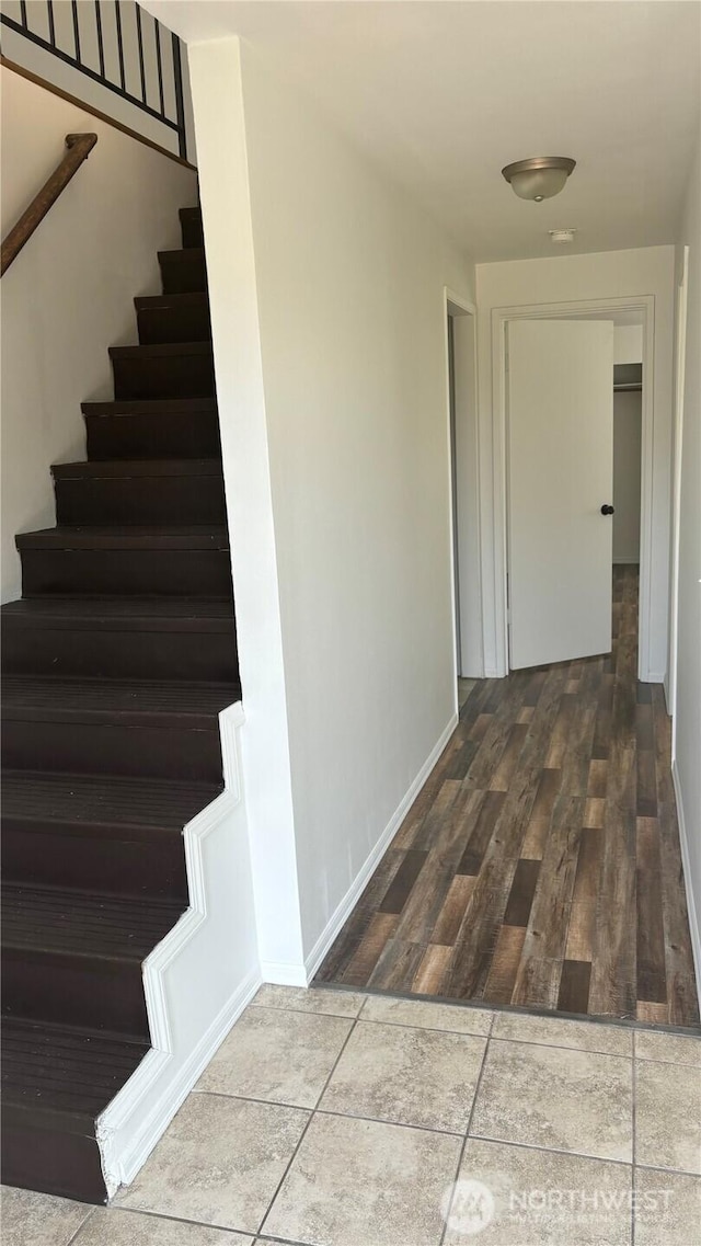 hall featuring wood finished floors, baseboards, and stairs