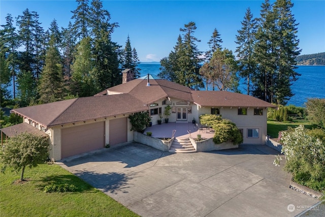 view of front of property featuring a garage and a water view