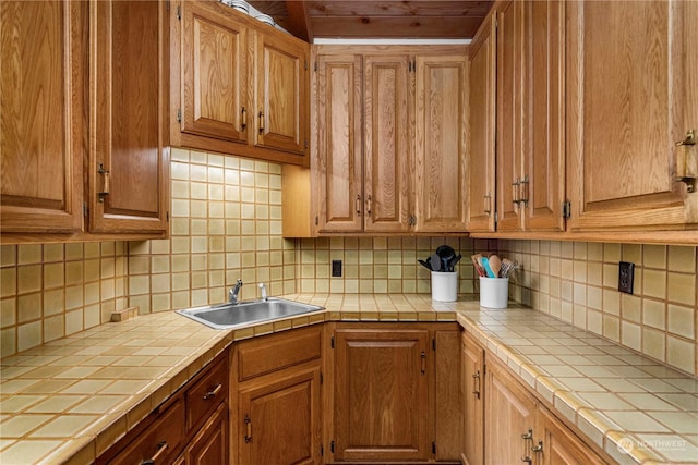 kitchen with sink, tile counters, and decorative backsplash