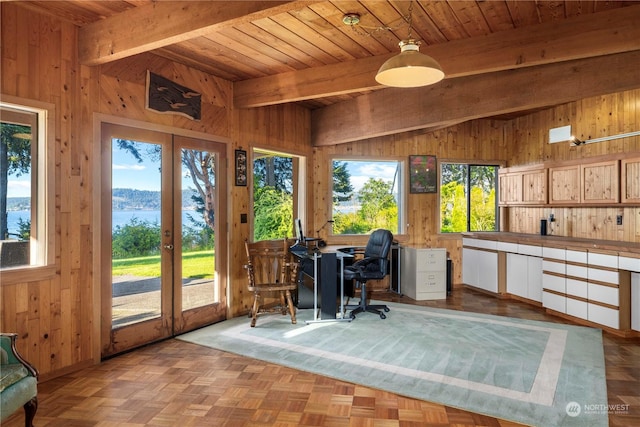 office area with a water view, wood walls, and french doors