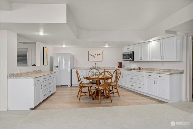 dining area with sink and light wood-type flooring