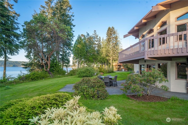 view of yard with a deck with water view and a patio area