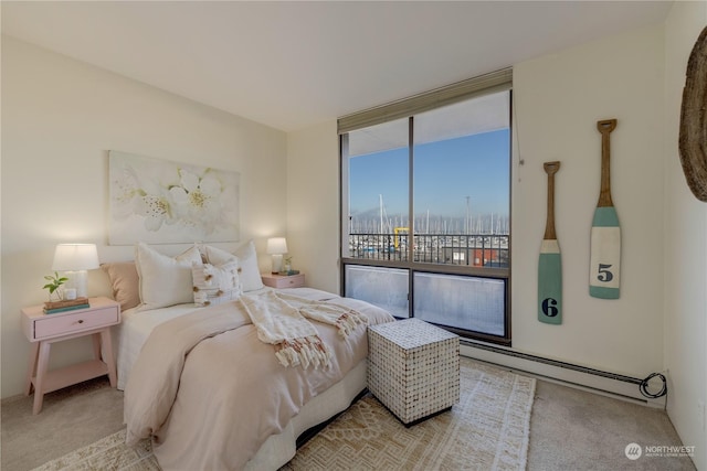 carpeted bedroom featuring a baseboard heating unit and access to outside