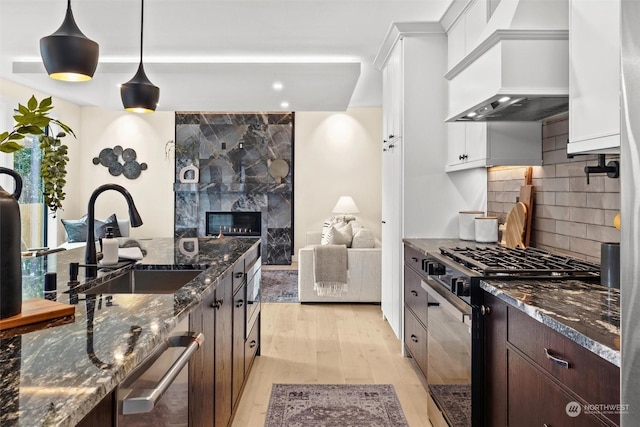 kitchen featuring pendant lighting, sink, appliances with stainless steel finishes, dark brown cabinetry, and white cabinets