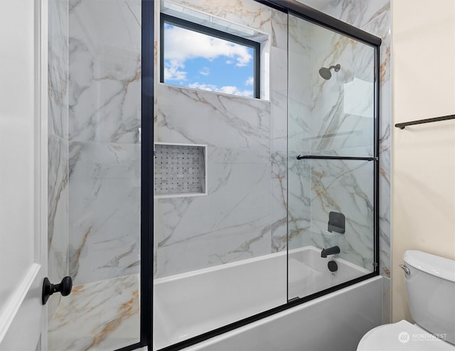 bathroom featuring toilet and combined bath / shower with glass door