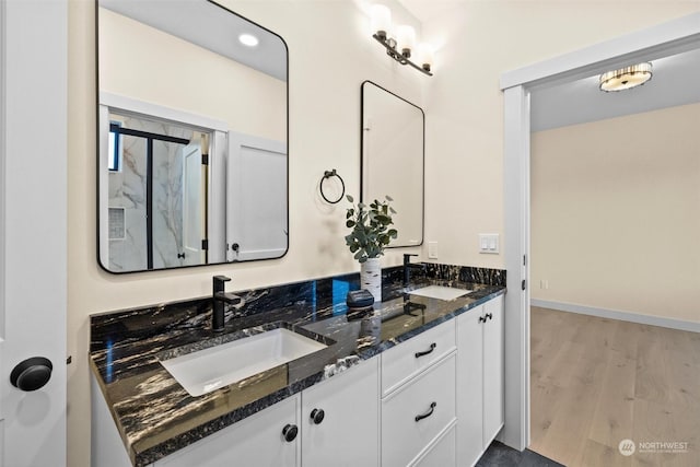 bathroom featuring hardwood / wood-style flooring, vanity, and walk in shower