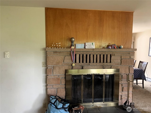 details featuring a stone fireplace and carpet