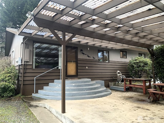 property entrance featuring a patio and a pergola