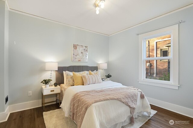 bedroom with ornamental molding and dark wood-type flooring