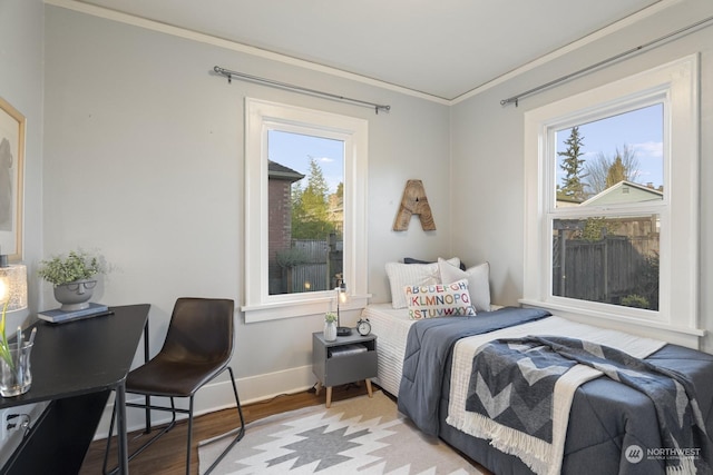 bedroom with ornamental molding and light wood-type flooring