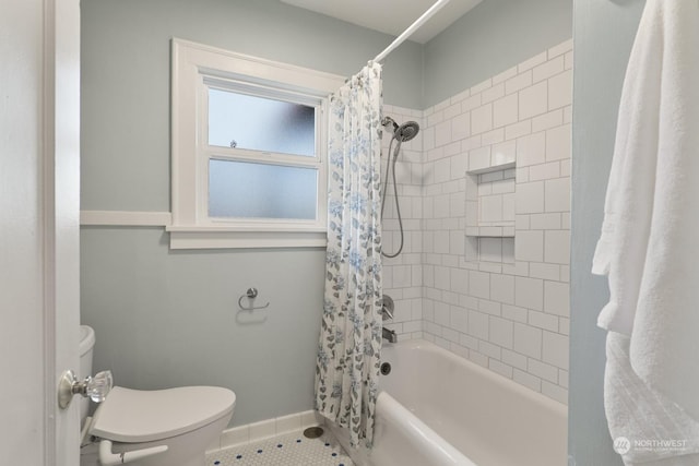 bathroom featuring toilet, tile patterned floors, and shower / tub combo with curtain