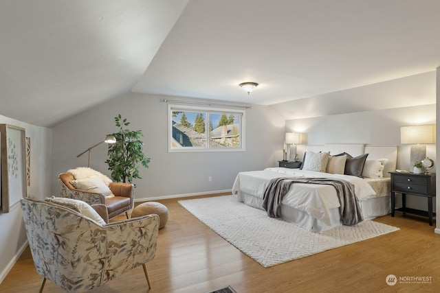 bedroom with lofted ceiling and light hardwood / wood-style flooring