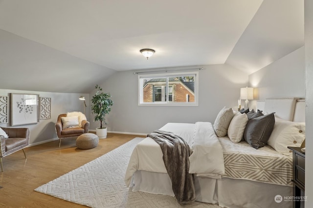 bedroom featuring vaulted ceiling and light hardwood / wood-style floors