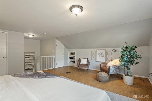 unfurnished bedroom featuring lofted ceiling and hardwood / wood-style floors