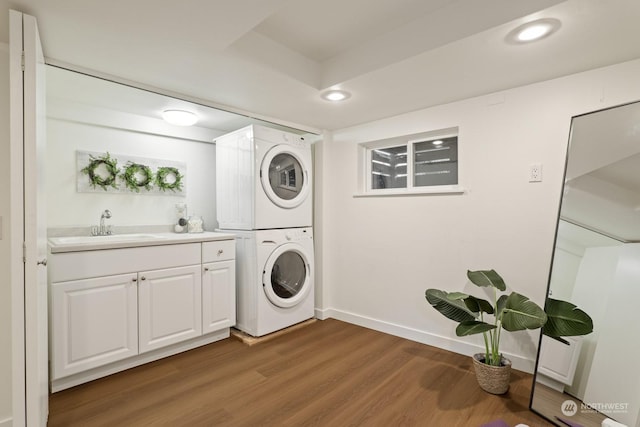 laundry room featuring stacked washing maching and dryer, sink, and hardwood / wood-style floors