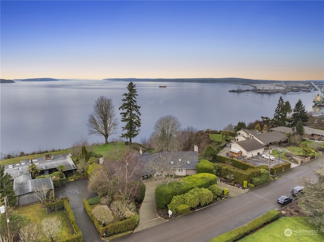 aerial view at dusk featuring a water view