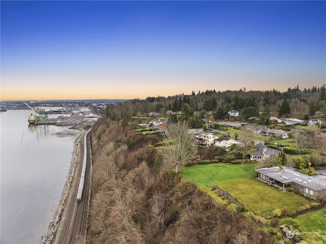 aerial view at dusk featuring a water view