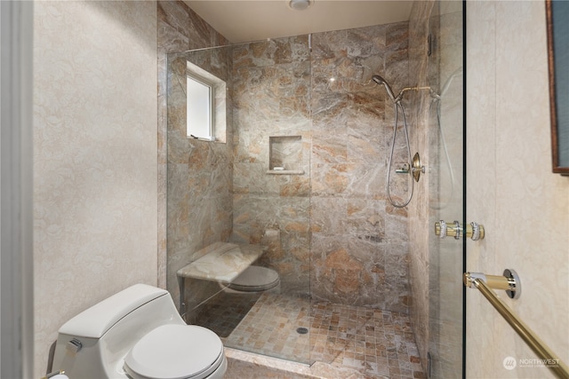 bathroom featuring a tile shower and toilet