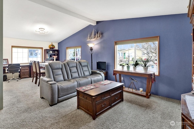 carpeted living room with plenty of natural light and lofted ceiling with beams