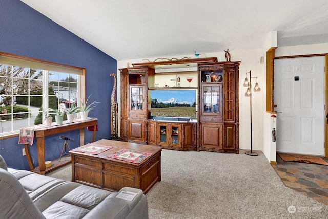 carpeted living room with lofted ceiling