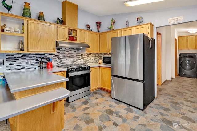 kitchen with washer / dryer, gas range, stainless steel refrigerator, kitchen peninsula, and backsplash