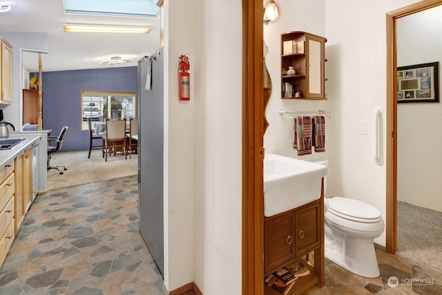 bathroom featuring lofted ceiling, vanity, and toilet