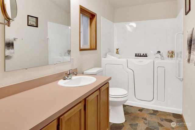 bathroom with vanity, a bathtub, and toilet