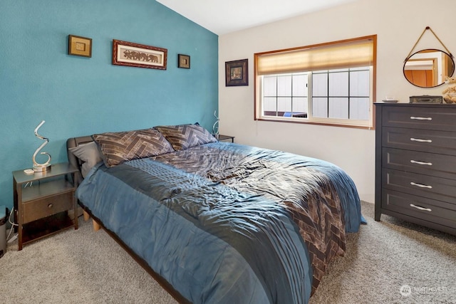 carpeted bedroom with vaulted ceiling