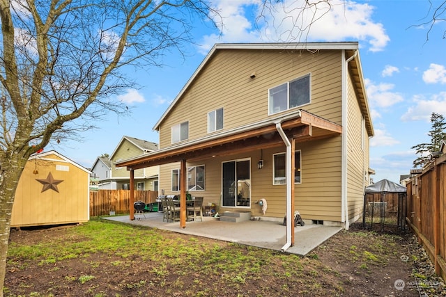 rear view of house featuring a patio and a storage unit