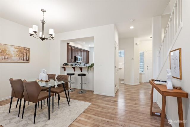 dining area with a chandelier and light hardwood / wood-style floors