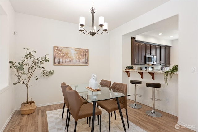 dining space with an inviting chandelier and light wood-type flooring