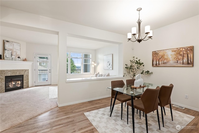 dining area with an inviting chandelier and light hardwood / wood-style flooring