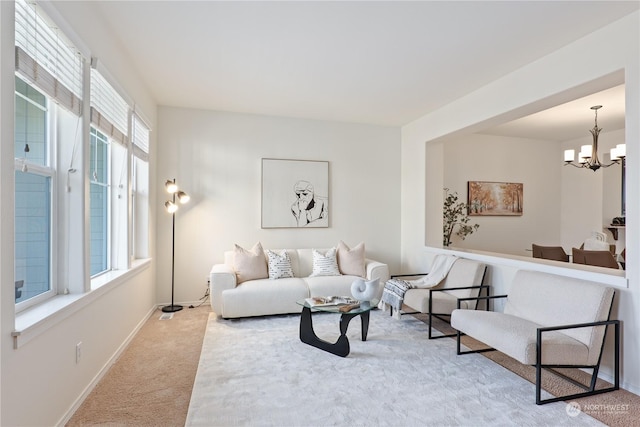 living room with carpet and an inviting chandelier