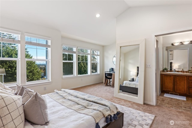 bedroom featuring light carpet, sink, connected bathroom, and vaulted ceiling