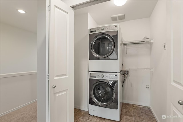 clothes washing area featuring stacked washer / drying machine