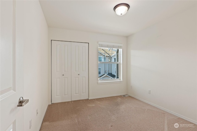 unfurnished bedroom with carpet and a closet