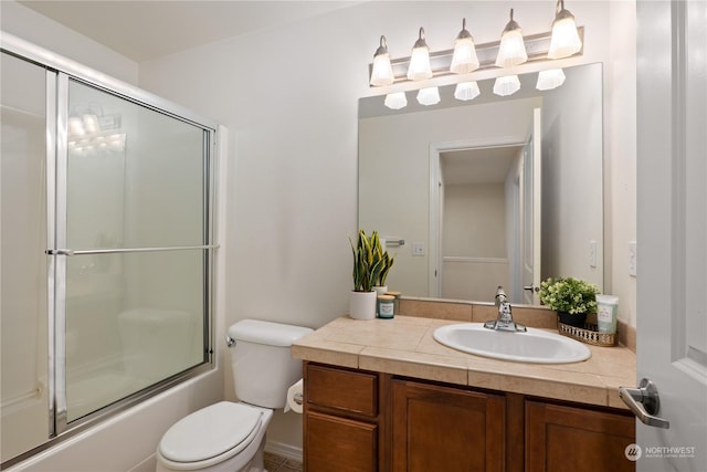 full bathroom featuring bath / shower combo with glass door, vanity, and toilet