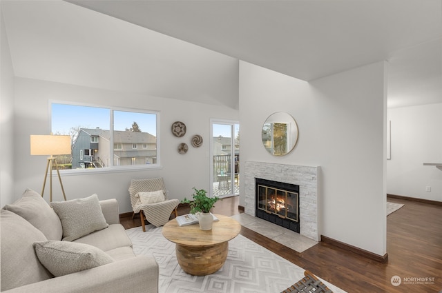 living room with vaulted ceiling, a fireplace, and hardwood / wood-style floors